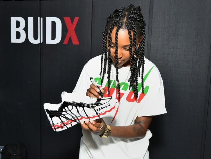 South African illustrator Karabo Poppy applying paint to a pair of sneakers