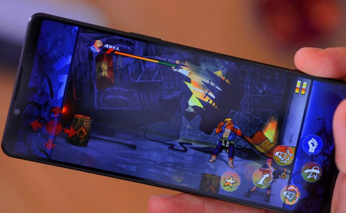 A hand holding smartphone with mobile game