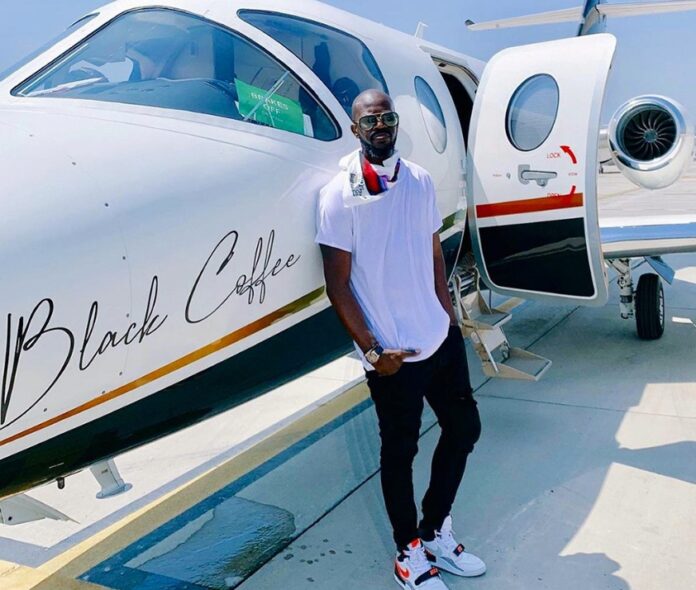 South African DJ Black Coffee standing next to a plane.