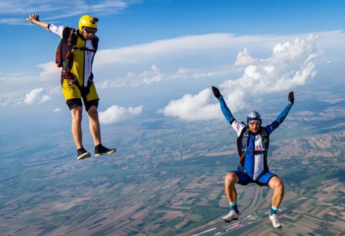 Enthusiastic skydiving pair hanging in the air