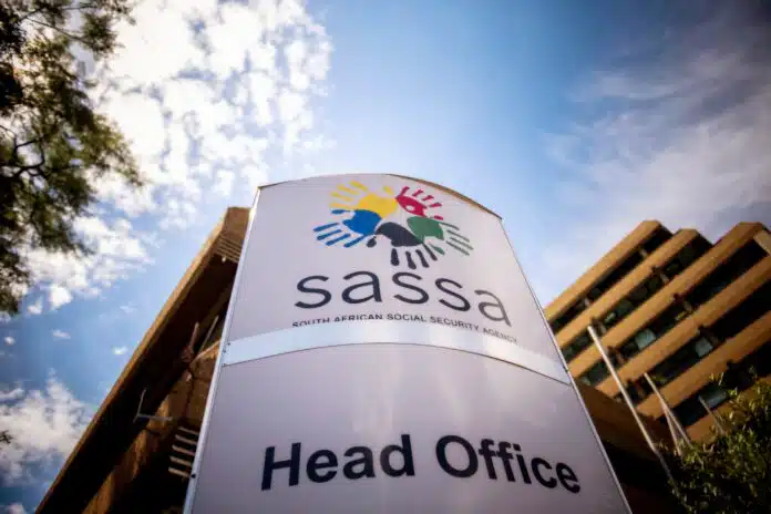 Sign for SASSA Head Office featuring the colorful handprint logo outside the agency's main building entrance.
