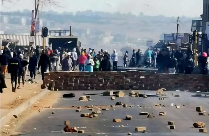 Protesters in Tembisa block a road with bricks and stones during a demonstration