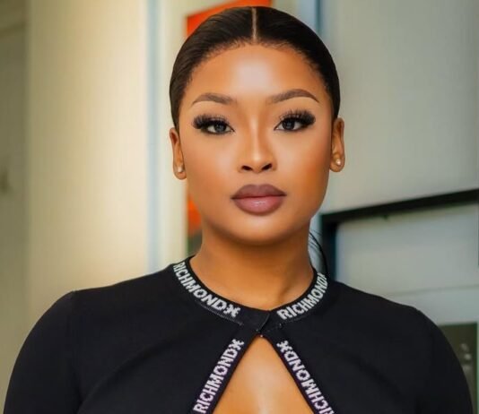 SIU responds to claims linking influencers to corruption probe A portrait of South African influencer and DJ Cyan Boujee, styled in a sleek black outfit with branded strap detailing across the neckline. She wears bold makeup with defined lashes and has her hair neatly tied back. The image is taken indoors with a softly blurred background.