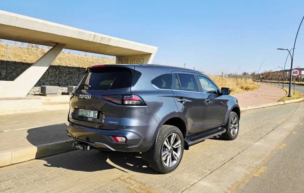 Rear view of a grey Isuzu MU-X Onyx 2025 SUV parked near a bus stop