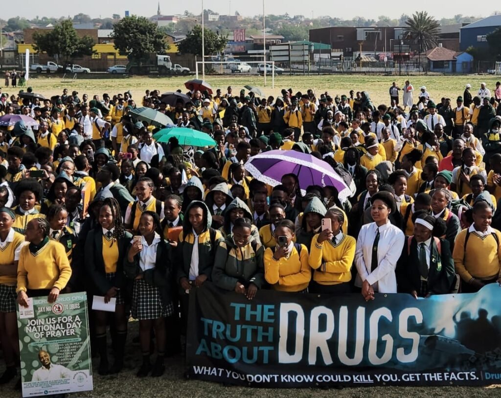 Hoërskool Elsburg learners hold anti-drug banner at Pastor Kabelo Mabalane's 23 years sobriety celebration.