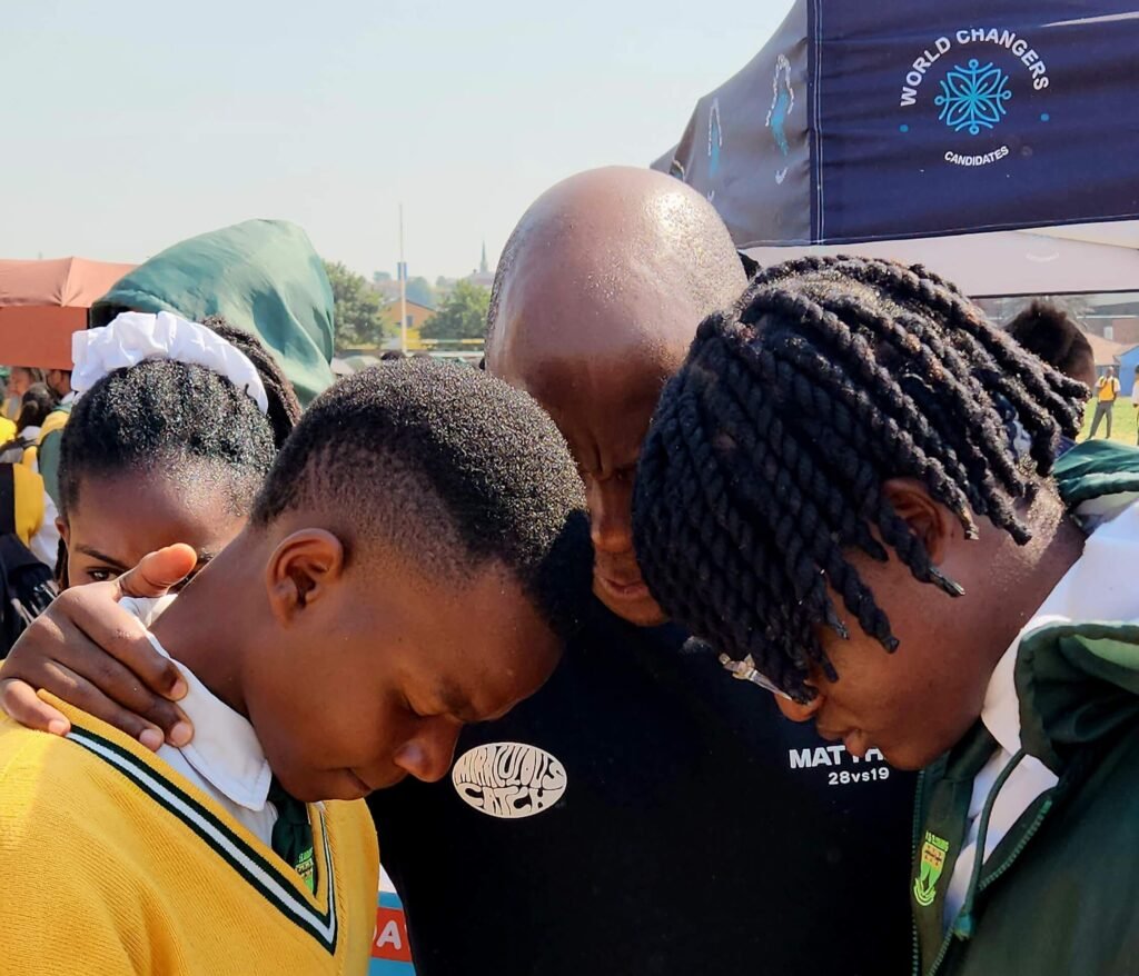 Pastor Kabelo lays hands on Hoërskool Elsburg learners in prayer.