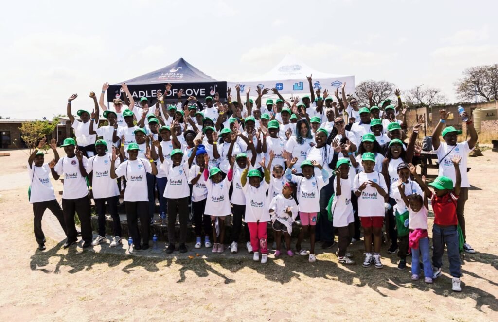 Group of VW volunteers raising hands at Leap 4 Science Diepsloot event.