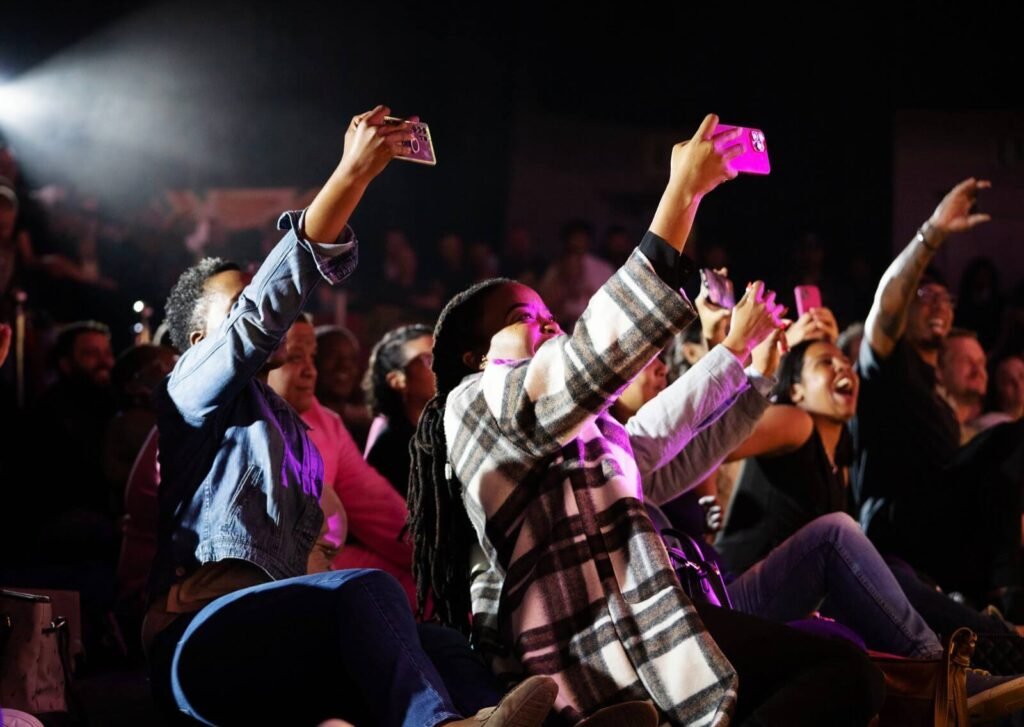 Excited audience recording a live event.