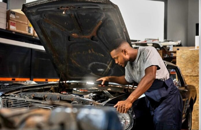 Skilled auto mechanic working on a car engine.