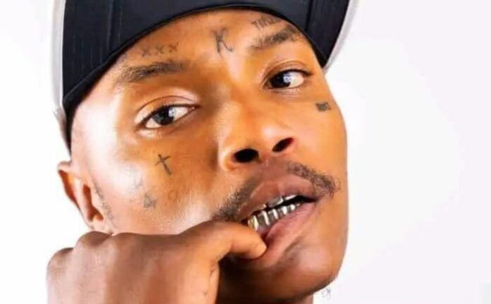 Close-up of Shebeshxt with facial tattoos and gold teeth.