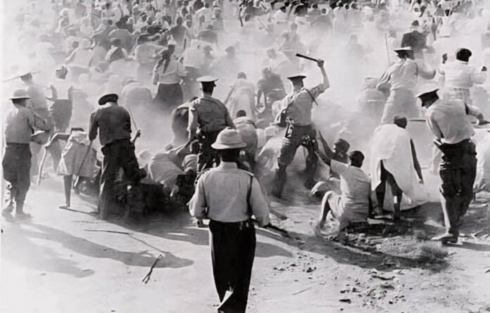 Historical photo showing apartheid-era South African police on horseback confronting a crowd during enforced segregation.