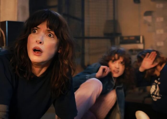Joyce Byers, Nancy Wheeler, Robin Buckley look on in horror in a scene Stranger Things S5 scene.
