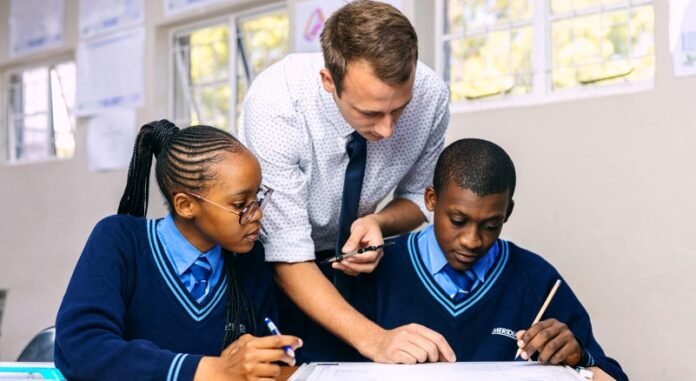 Teacher assisting learners in a private school classroom at Curro Northern Academy