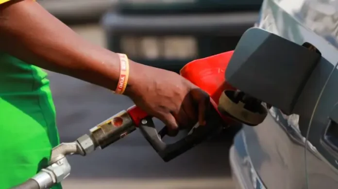 Petrol attendant refueling a car with a red nozzle at a South African service station; conceptual image for January 2026 fuel price drops.