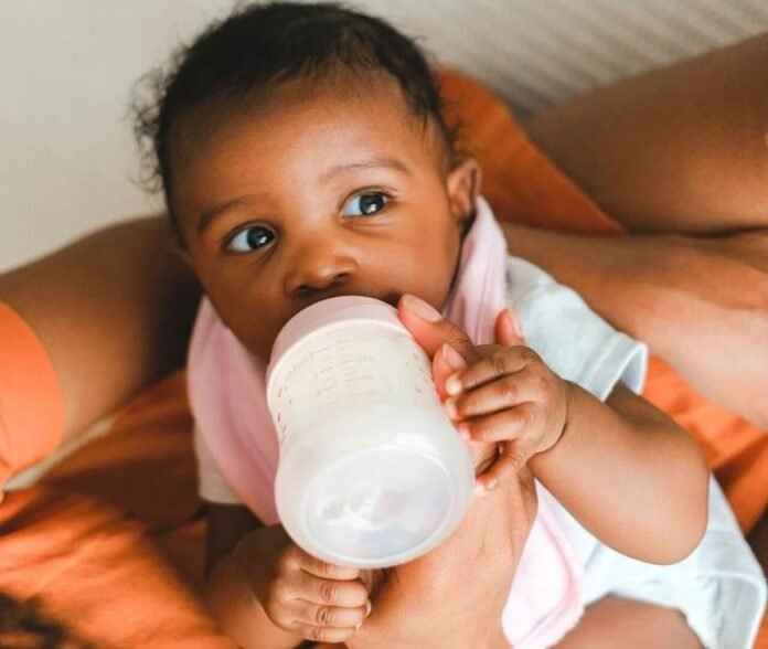 Baby drinking from bottle during Nestlé baby formula global recall alert.