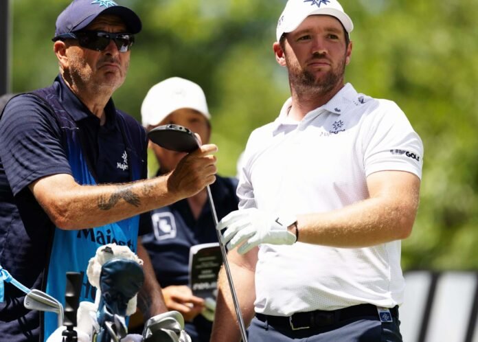 Sam Horsfield of Majesticks GC speaks with caddie Teddy Mundy during a LIV Golf tournament.