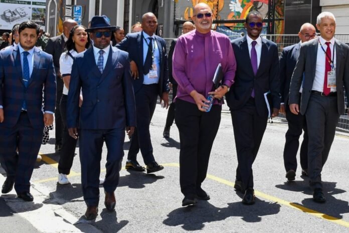 Enoch Godongwana walks with government officials outdoors at Nieuwmeester Dome, Cape Town, before the 2026 Budget presentation.