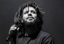 FNB Stadium set to shake: J. Cole brings The Fall-Off Tour to Johannesburg — Tickets & presale live J. Cole performing on stage during a live concert, holding a microphone, wearing a Dreamville t-shirt.