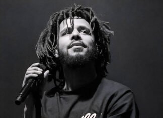FNB Stadium set to shake: J. Cole brings The Fall-Off Tour to Johannesburg — Tickets & presale live J. Cole performing on stage during a live concert, holding a microphone, wearing a Dreamville t-shirt.