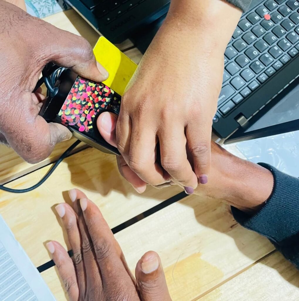 South African Social Security Agency (SASSA) beneficiary completing biometric fingerprint verification for SRD grant application.