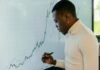 How Traders in South Africa Securely Access Online Trading Platforms Trader analysing live financial charts on a digital screen using a stylus.