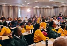 Learners challenge government over drugs in schools and whistleblower safety School learners in yellow and green blazers raise their hands at a CDA town hall meeting at the Birchwood Hotel in Boksburg, asking questions about drugs in schools while officials listen.