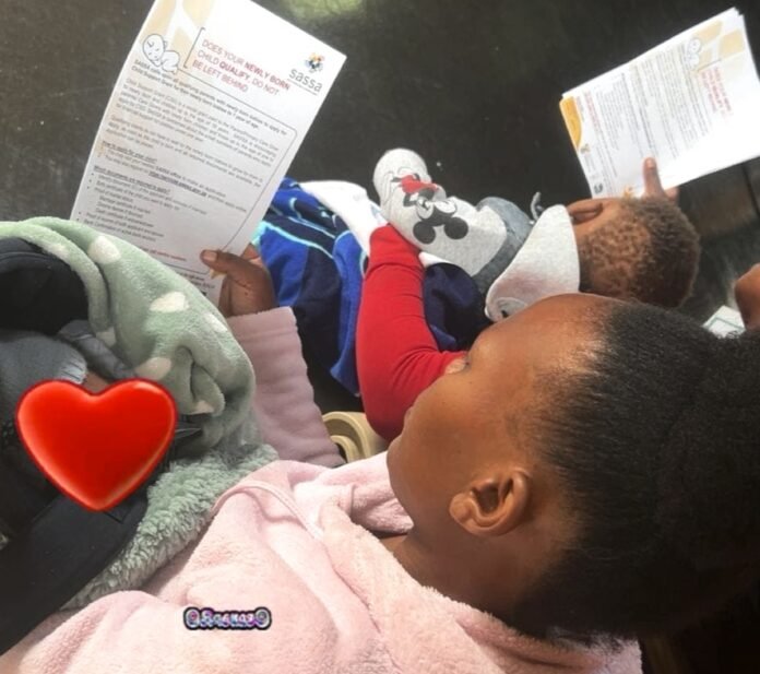 Caregiver holding SASSA Child Support Grant documents while sitting with a young child in South Africa.