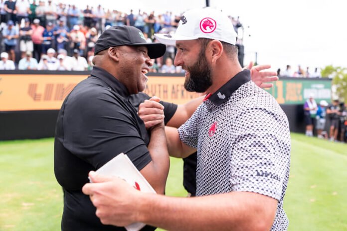 Gayton McKenzie greets Jon Rahm with a handshake and embrace at LIV Golf South Africa in front of a large crowd at Steyn City.