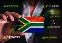 Key features traders evaluate when choosing trading platforms in South Africa Person holding South African flag with financial data and stock market trend lines in the background.