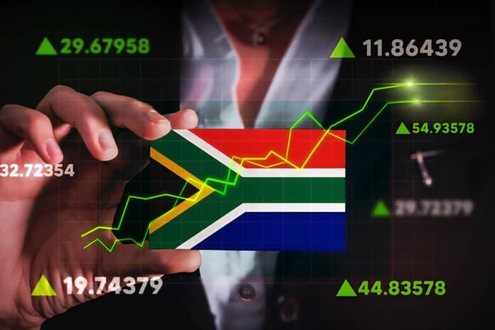 Person holding South African flag with financial data and stock market trend lines in the background.
