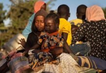 Sudan war: Chemical weapons allegations fuel calls for global probe Sudanese children and families displaced by war sit with belongings, reflecting the humanitarian crisis and impact of conflict on civilians.
