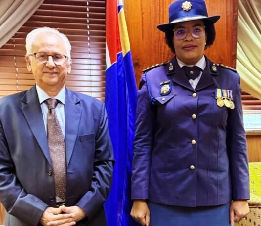 President appoints acting police commissioner as Masemola faces PFMA charges over R360m tender Firoz Cachalia and Acting SAPS National Commissioner Puleng Dimpane stand side by side in formal attire in front of a South African flag.