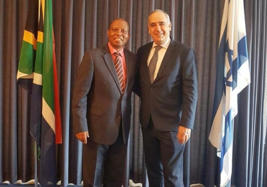 Herman Mashaba with Arthur Lenk in front of South African and Israeli flags.