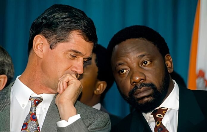 Close-up of Roelf Meyer and Cyril Ramaphosa in deep thought during CODESA negotiations. Meyer rests his chin on his hand while Ramaphosa looks on with a focused expression.