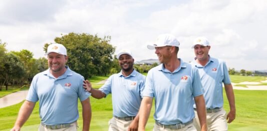 LIV Golf Smash GC rebrands to OKGC, following South Africa’s lead OKGC golfers Graeme McDowell, Harold Varner III, Talor Gooch and Jason Kokrak walk together laughing on a green fairway in matching uniforms.