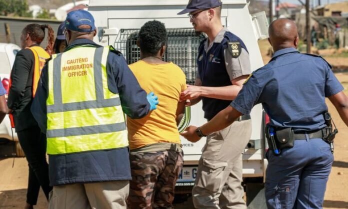 South African immigration officers arrest suspected undocumented migrant during Operation New Broom crackdown in Gauteng.