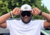 ‘I was just trolling’ – Scooby Nero apologises for RDP claims, admits he ‘didn’t read the room’ Scooby Nero in white polo and aviator sunglasses adjusting a two-tone cap with green brim and crest.