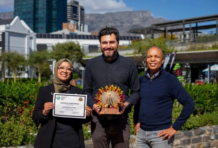 V&A Waterfront team holding certificate and trophy after V&A Academy wins Gold for local economic benefit in Cape Town.