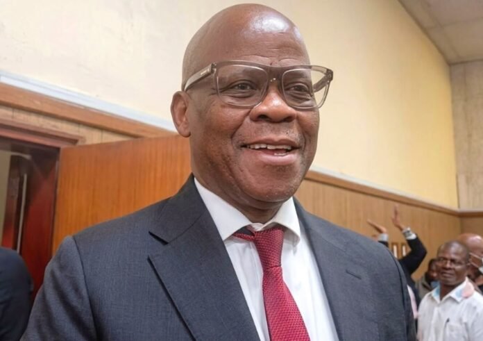 Taxi boss Joe 'Ferrari' Sibanyoni smiling in a grey suit after walking free from court due to the big 5 cartel extortion case collapse.