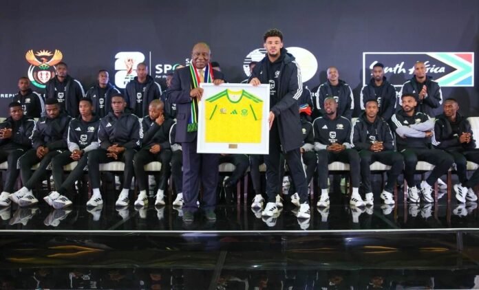 President Ramaphosa holds framed Bafana jersey at World Cup send-off.