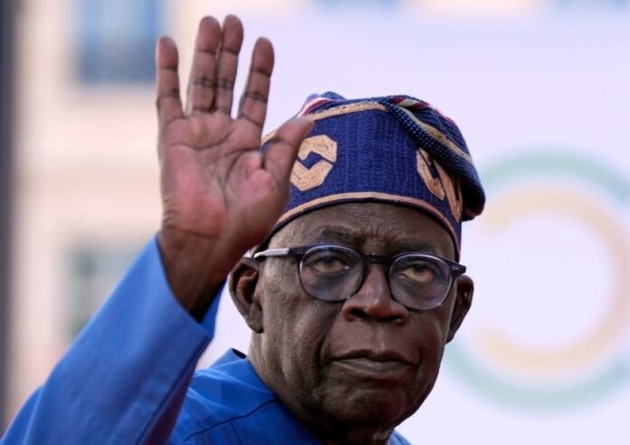 Nigeria President Bola Tinubu raises his hand during a public appearance amid Nigeria's 2026 repatriation programme