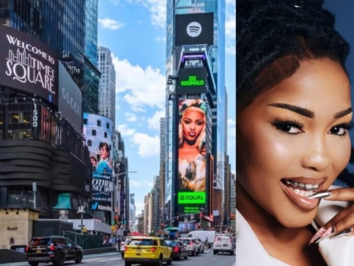 Zee Nxumalo alongside her Spotify EQUAL Times Square billboard in New York, highlighting her growing global success.