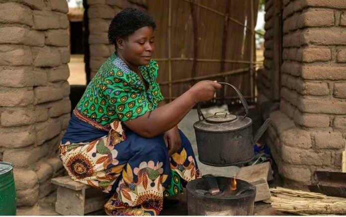 Makhazi, 37, prepares a kettle outside her home after investing her Canva-funded direct cash transfer in her tea business.