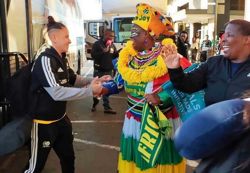 Mama Joy greets Gabriela Moodaly-Salgado during Banyana Banyana's WAFCON departure at OR Tambo Airport.