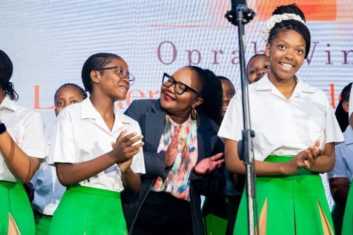 OWLAG learners perform with Minister Siviwe Gwarube beneath an Oprah Winfrey Leadership Academy backdrop in South Africa
