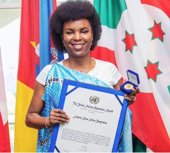 Burundi First Lady Angeline Ndayishimiye holds her UN Population Award certificate and medal.