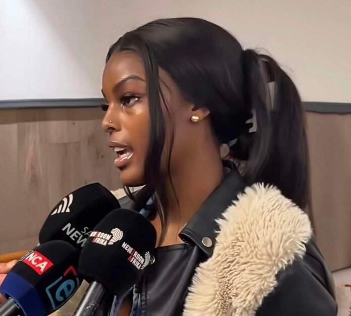 Chidimma Adetshina speaks to reporters outside court, with several microphones held towards her.