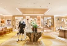 Louis Vuitton opens new flagship store at Cape Town’s V&A Waterfront Louis Vuitton Cape Town flagship interior with dressed mannequins beside a glass table on a carved wood base