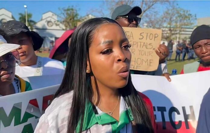 Ngobese-Zuma, March and March leader, speaks to media at anti-immigration protest surrounded by supporters