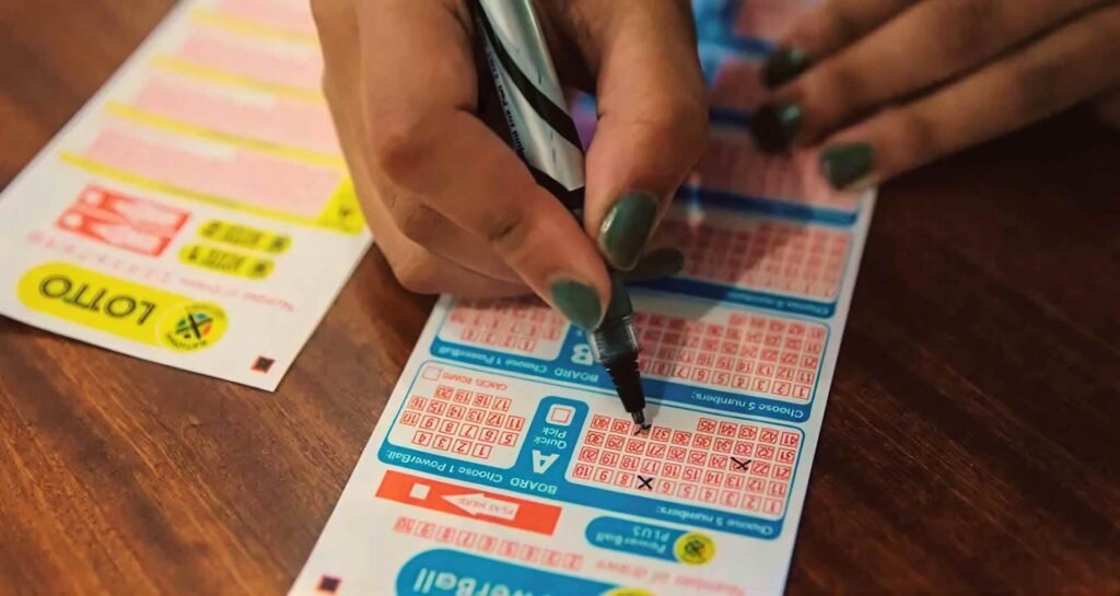 Hand marking numbers with a pen on a South African National Lottery playslip.